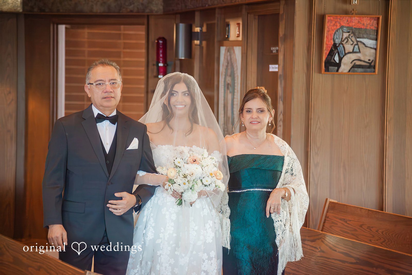 Bride walking down the aisle accompanied by two people.