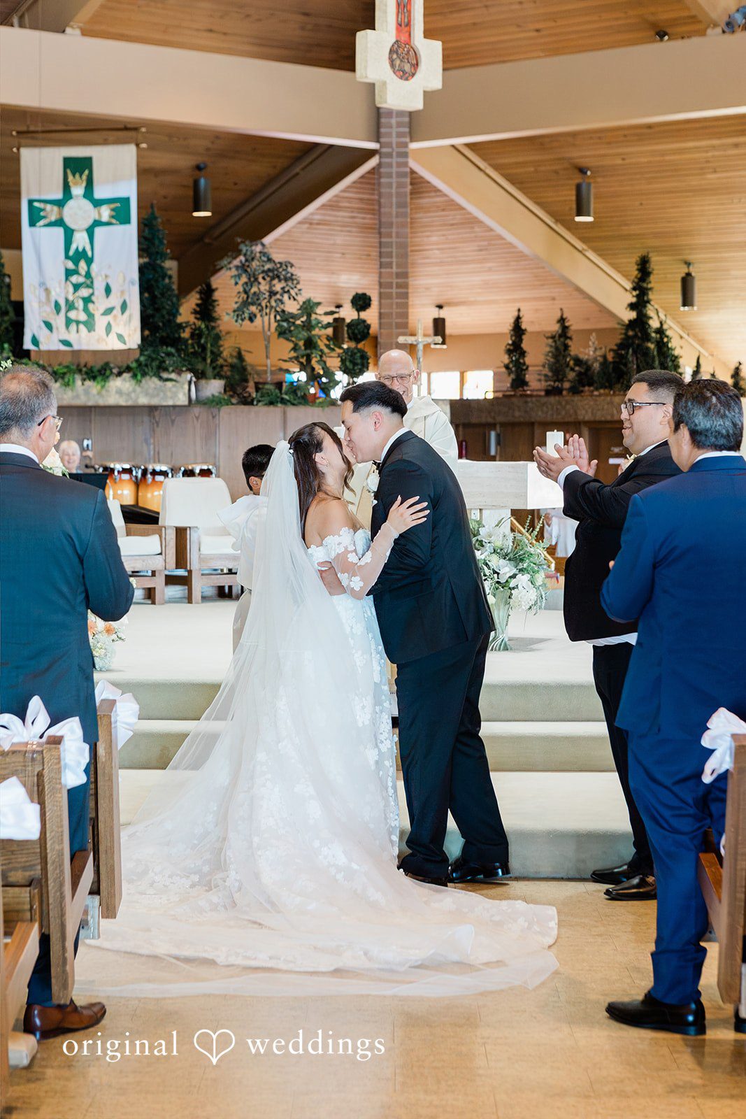 Bride and groom sharing a kiss at the altar in a church.