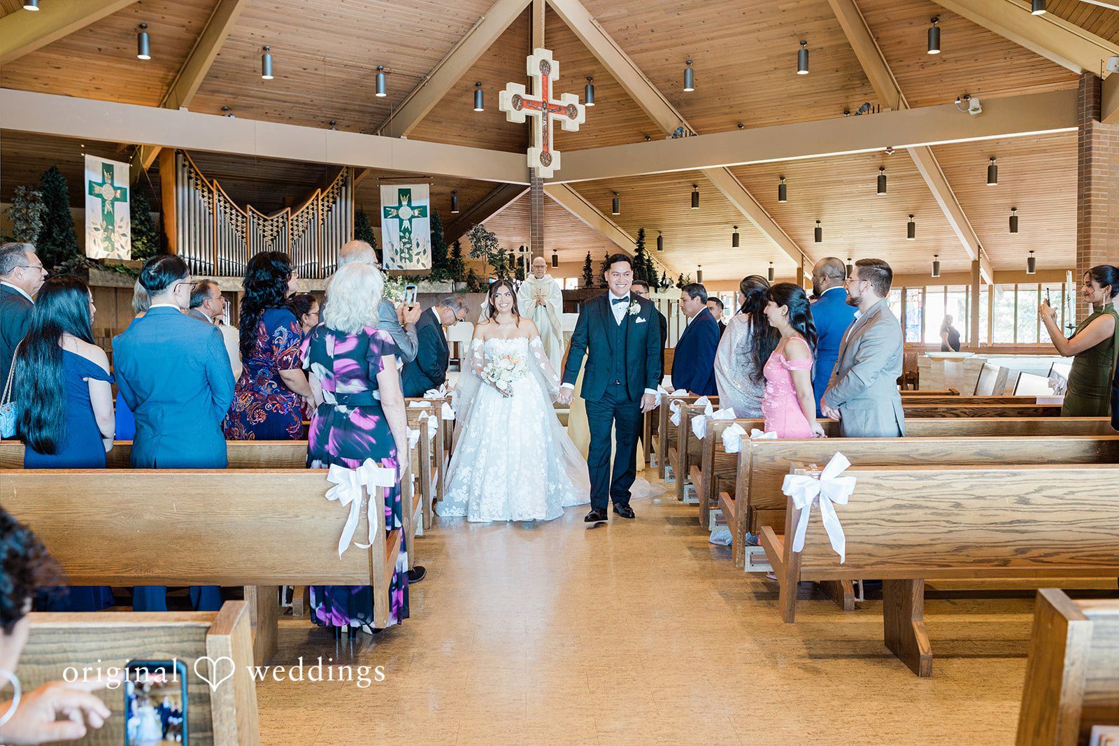 Newlyweds walking down the church aisle together after the ceremony.