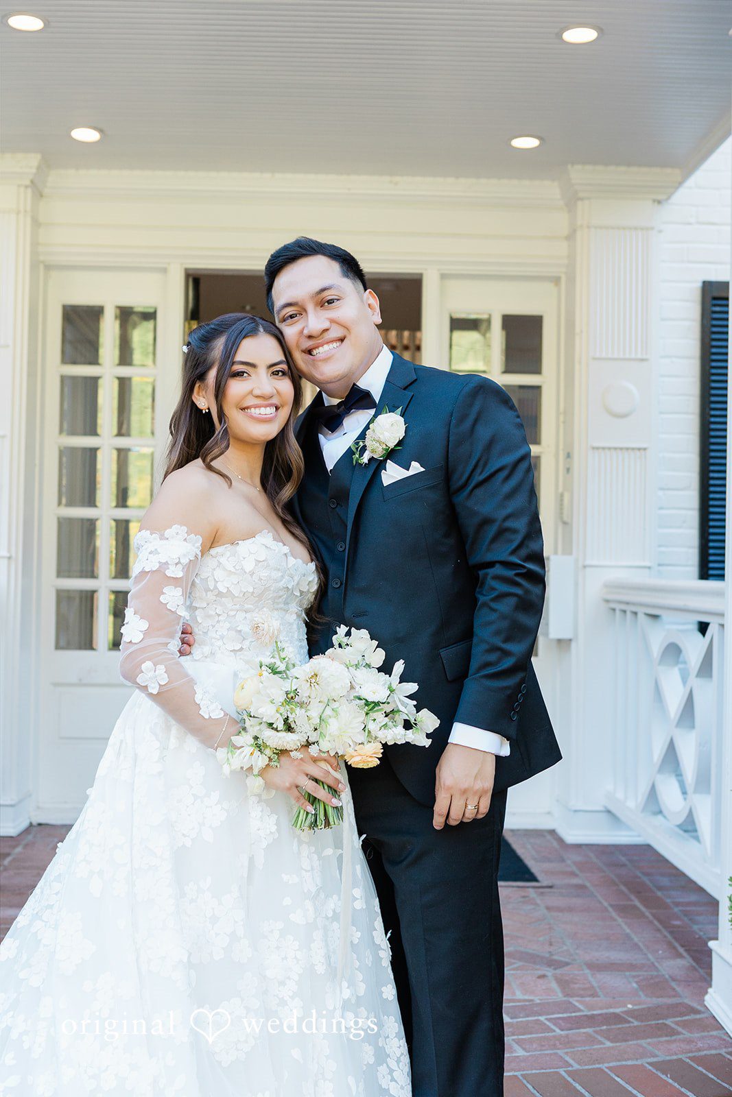 Smiling bride holding a bouquet next to the groom.