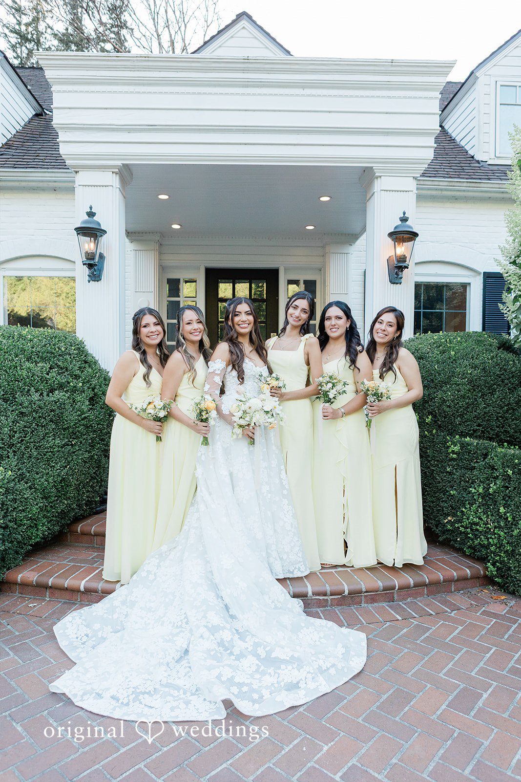 Bride posing with her bridesmaids in front of a building.