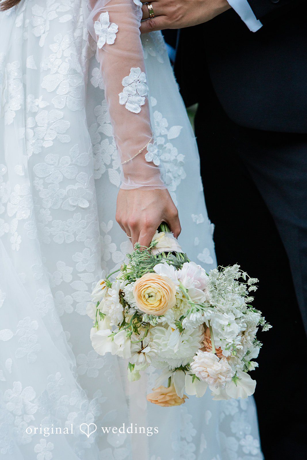 Close-up of a bride holding a white and yellow floral bouquet.