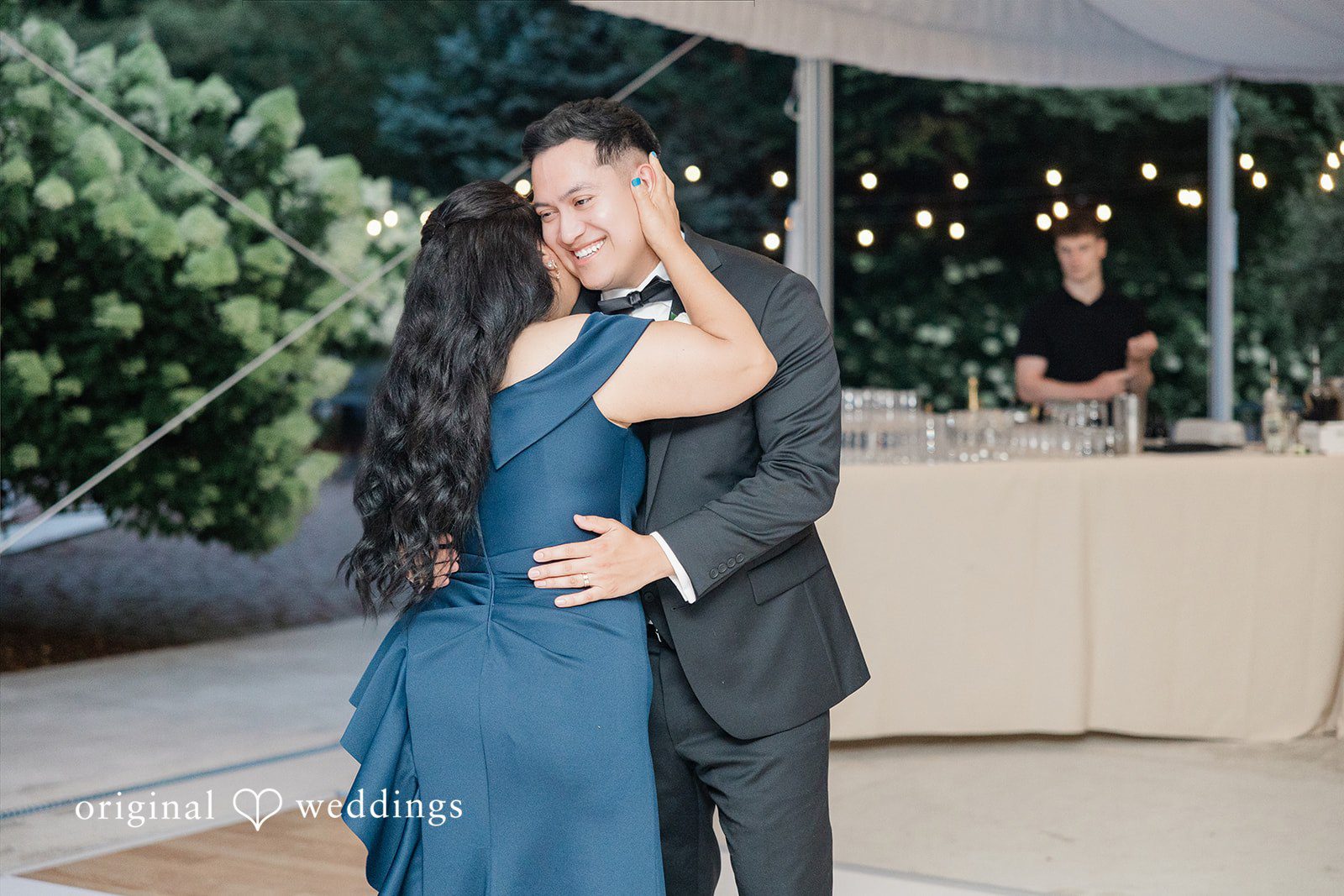 Man in a suit dancing with a woman in a blue gown.