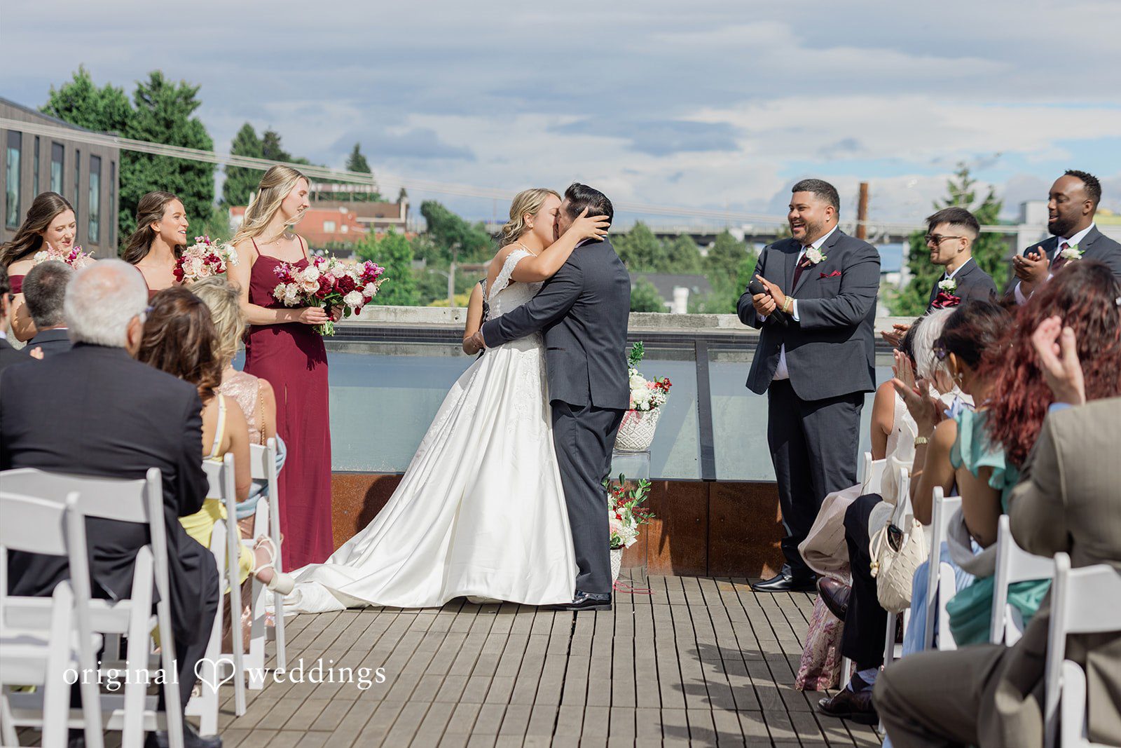 Michelle + Eric A bride and groom kissing at the altar during their rooftop wedding ceremony.