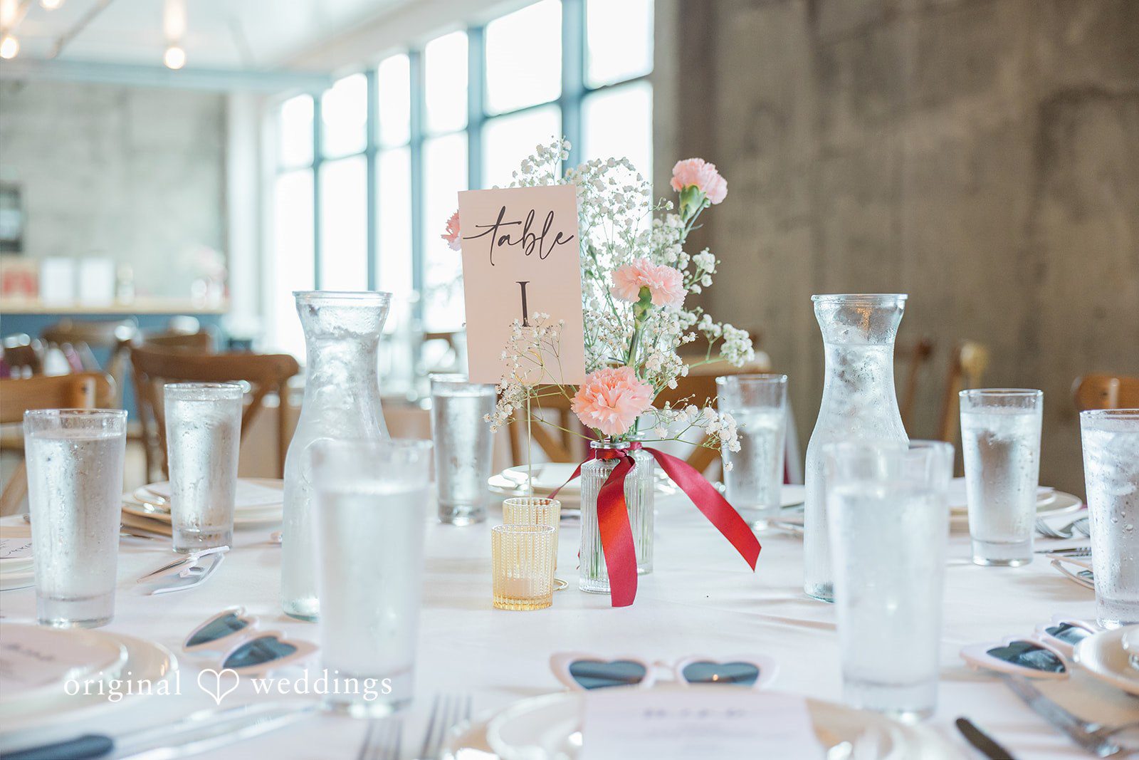 Michelle + Eric A decorated reception table featuring a floral arrangement and a table number sign.