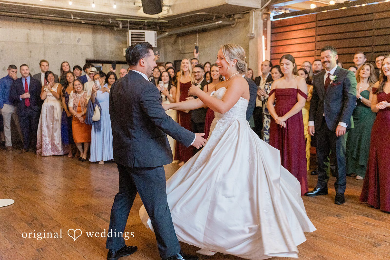 Michelle + Eric A bride and groom sharing their first dance while surrounded by watching wedding guests.