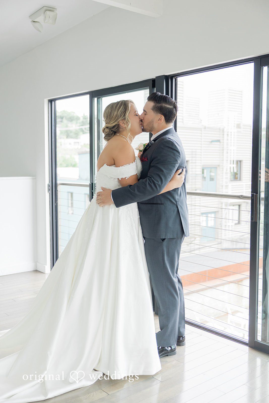 Michelle + Eric A bride and groom sharing a kiss in front of a window.