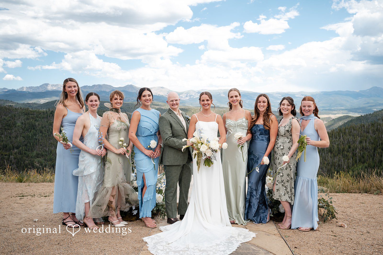 Emilia + Charlie A bride standing with her bridesmaids dressed in light blue gowns.