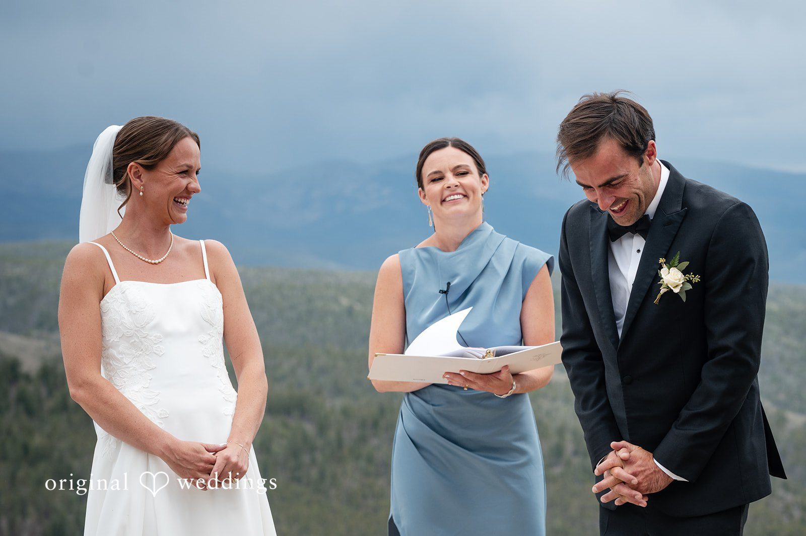 Emilia + Charlie A bride, a woman in a blue dress, and a groom standing at the altar.