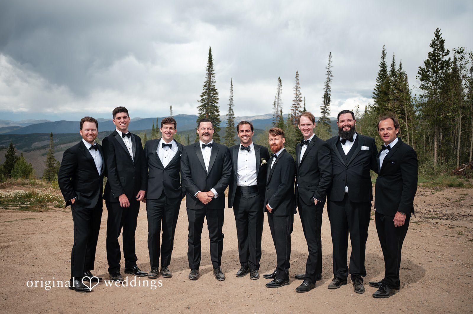 Emilia + Charlie A groom posing with his groomsmen in black suits.