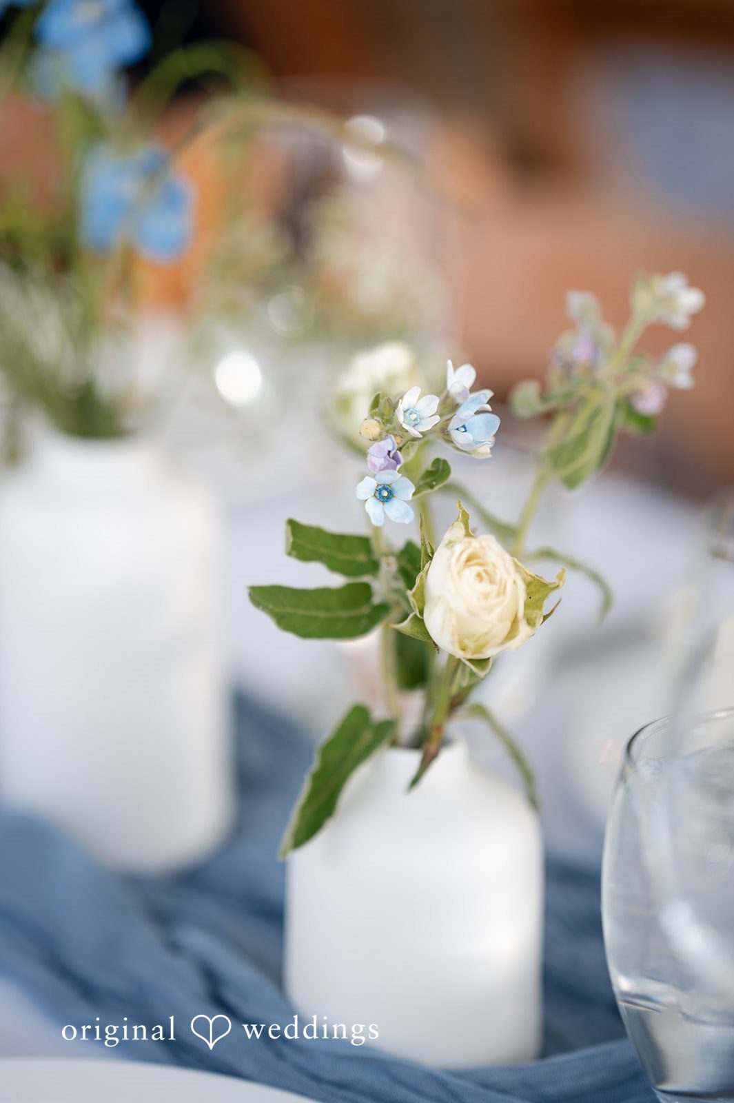 Emilia + Charlie A close-up of a small white floral centerpiece on a table.