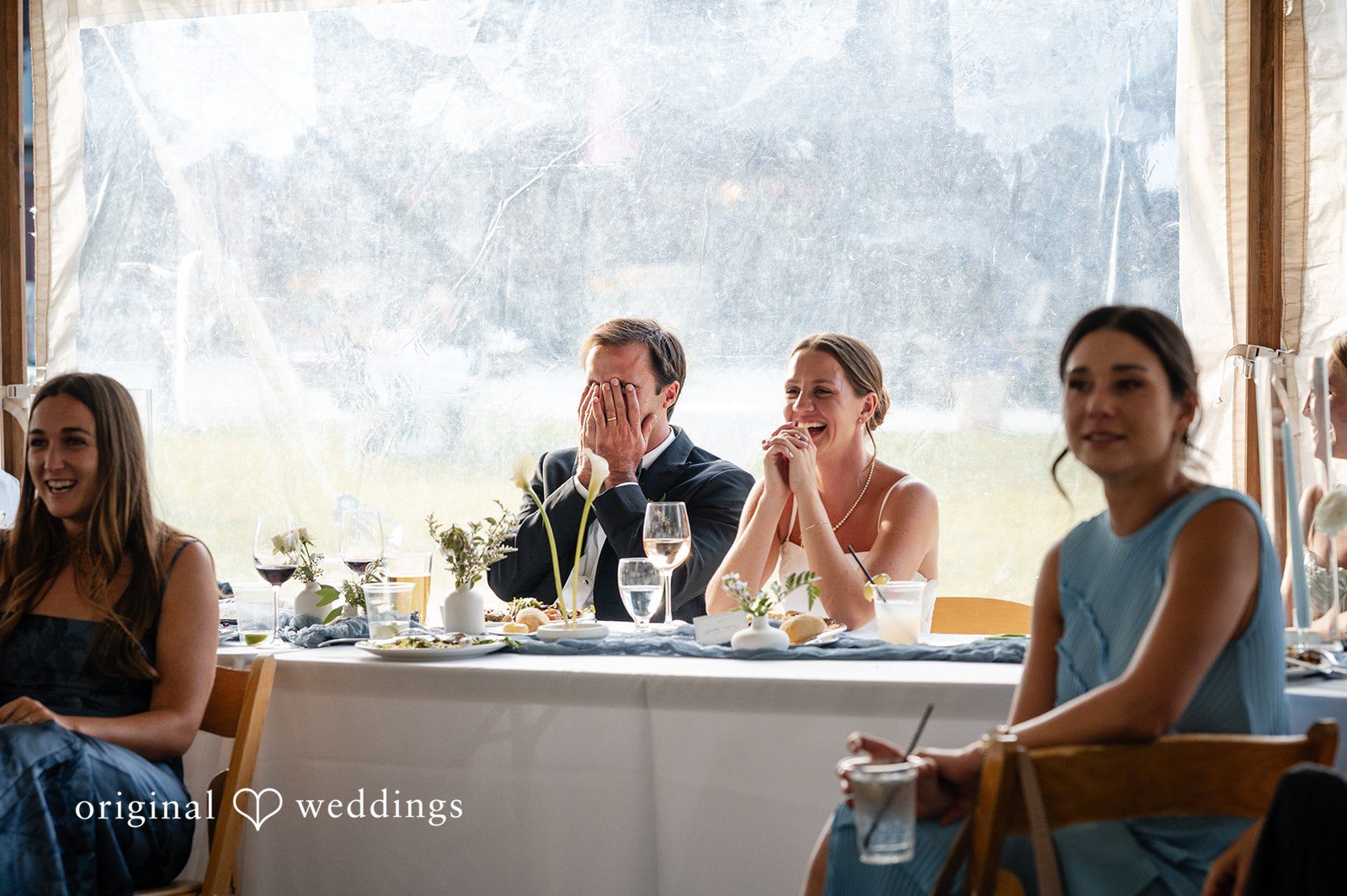 Emilia + Charlie Guests seated at a long head table during a wedding reception.