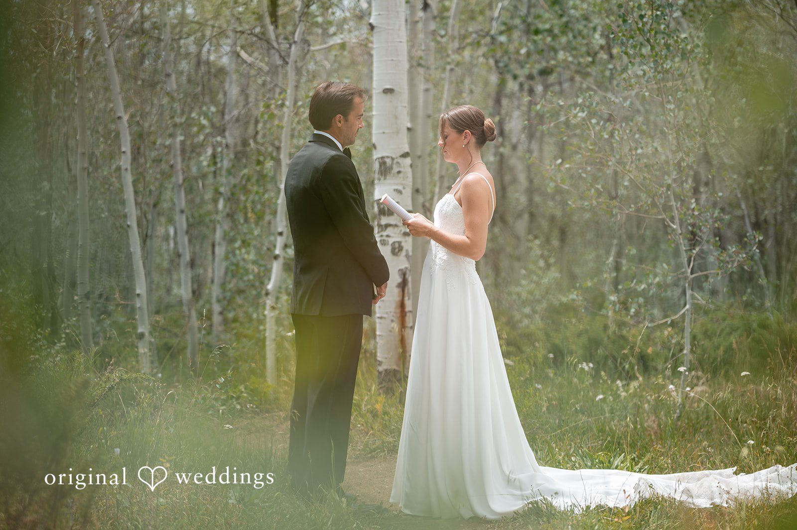 Emilia + Charlie A bride and groom exchanging vows in a forest.