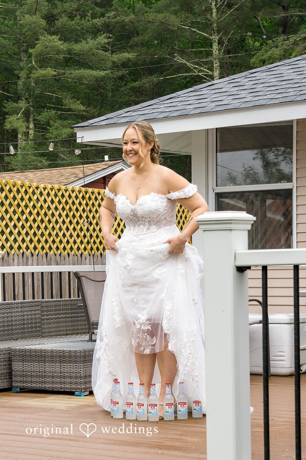 Alex + Courtney A bride in a white gown posing on a wooden deck.