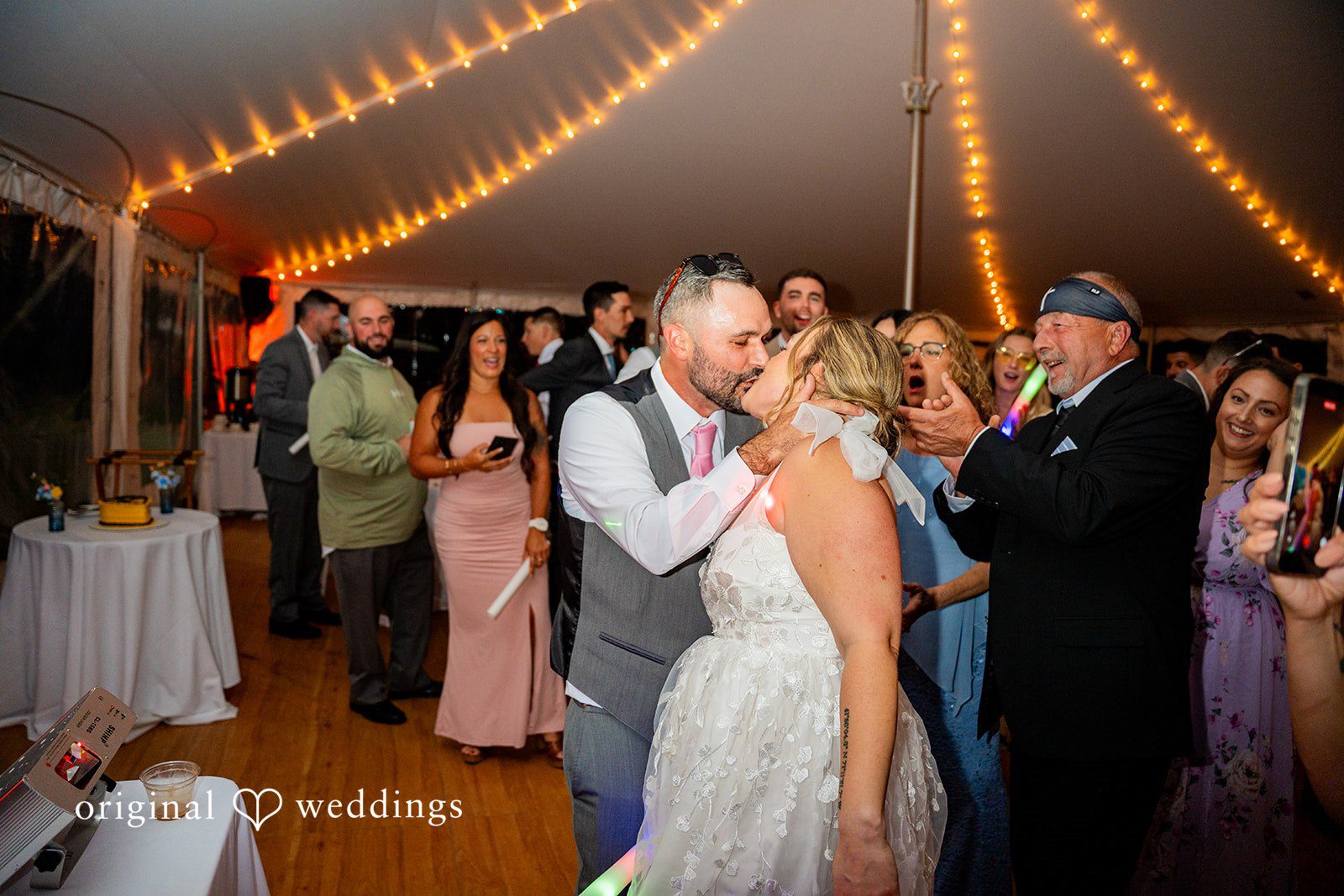 Alex + Courtney A bride and groom kissing at their wedding reception.