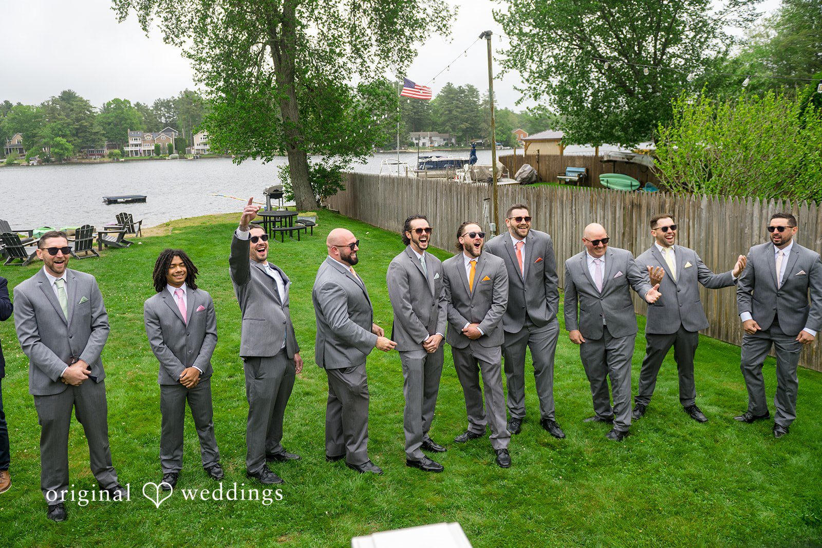 Alex + Courtney Groomsmen standing side-by-side on a lawn in matching grey suits.