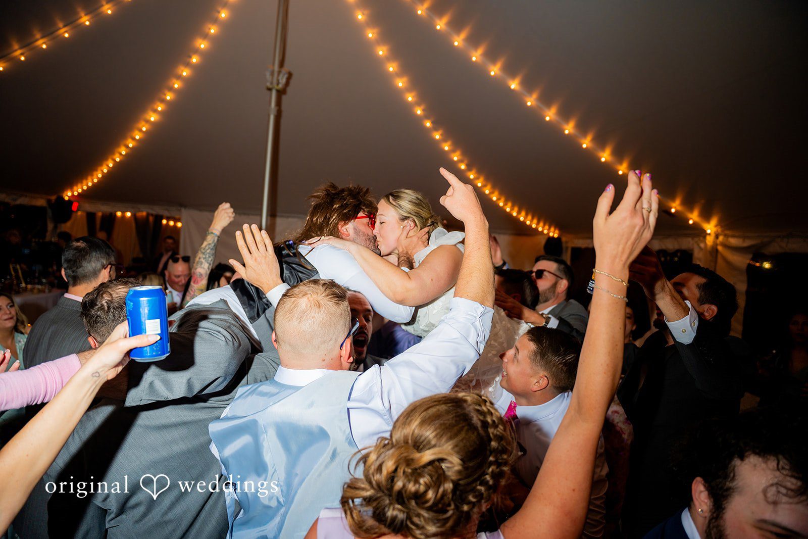 Alex + Courtney Guests cheering with raised hands on a crowded dance floor.