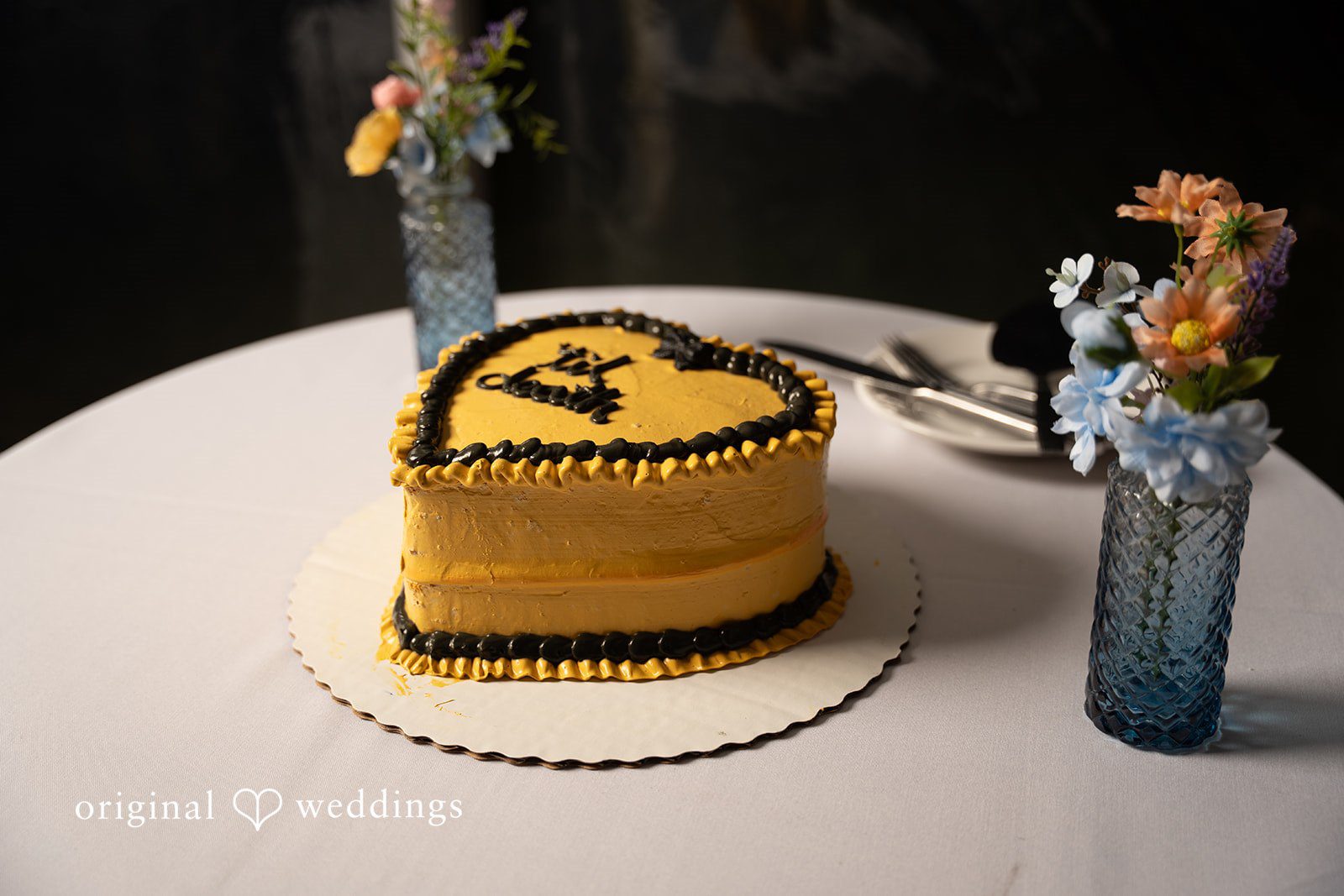 Alex + Courtney A small heart-shaped wedding cake sitting on a table.