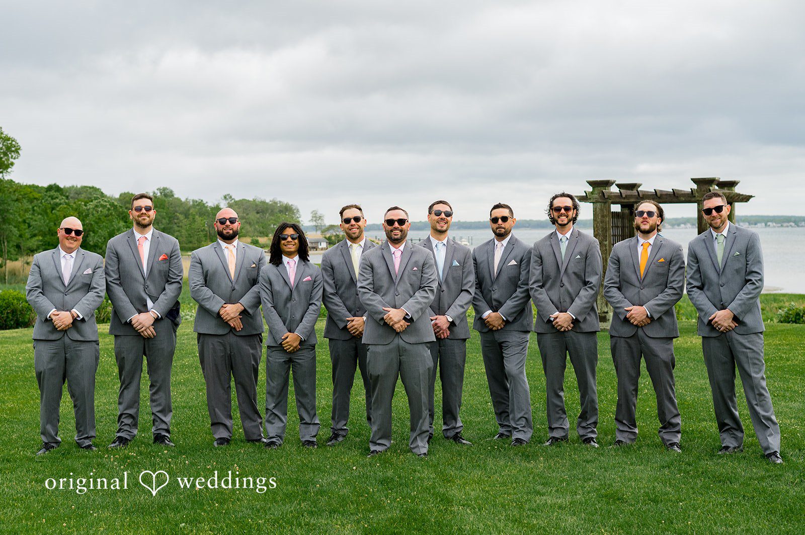 Alex + Courtney A large wedding party standing together in matching grey attire.