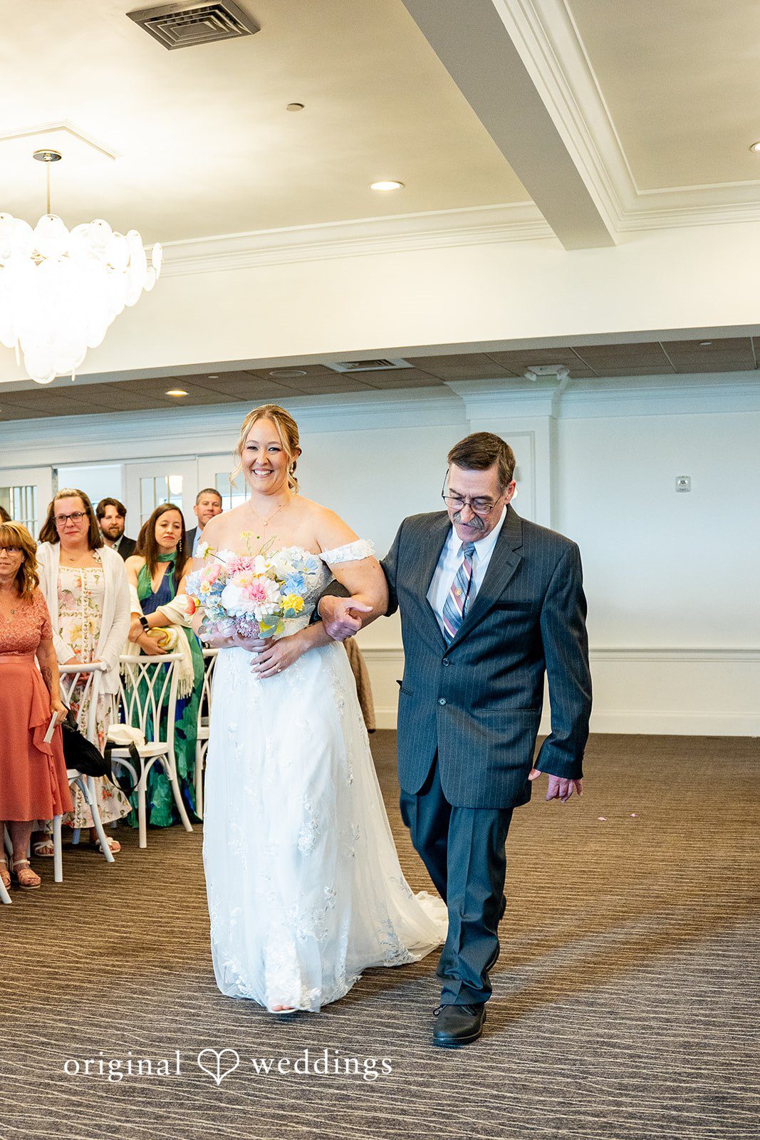 Alex + Courtney A bride and man walking together down a reception aisle.