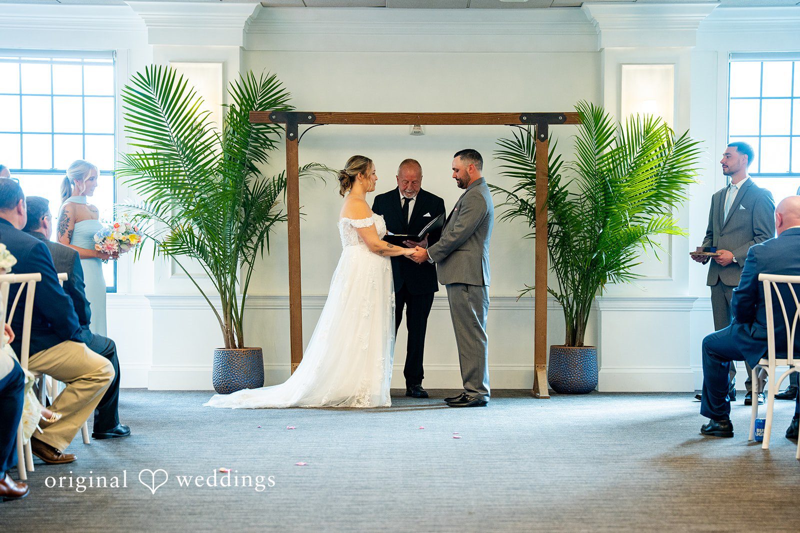 Alex + Courtney A wedding ceremony taking place in front of a wooden arch.