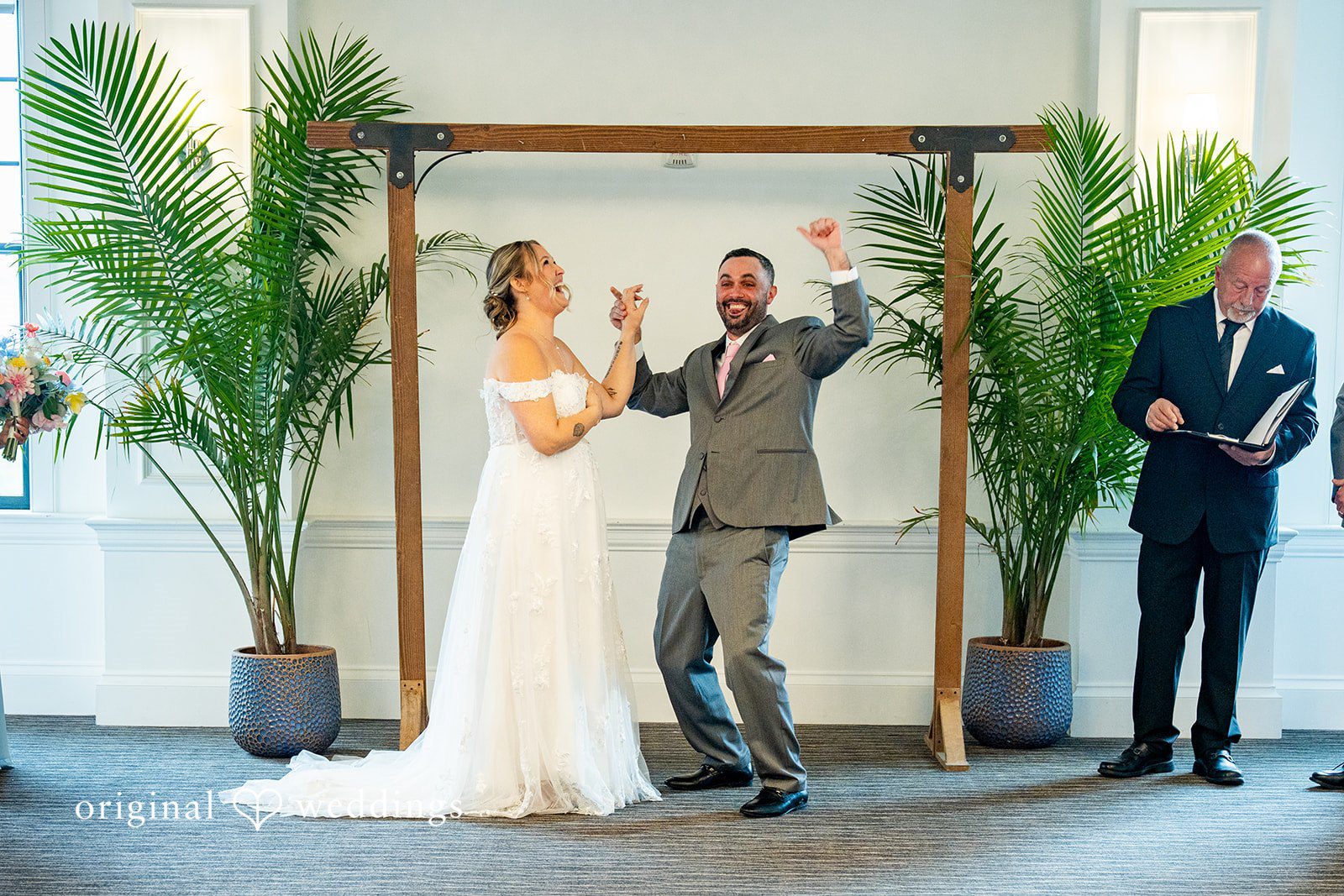 Alex + Courtney A bride and groom celebrating with raised hands after the ceremony.