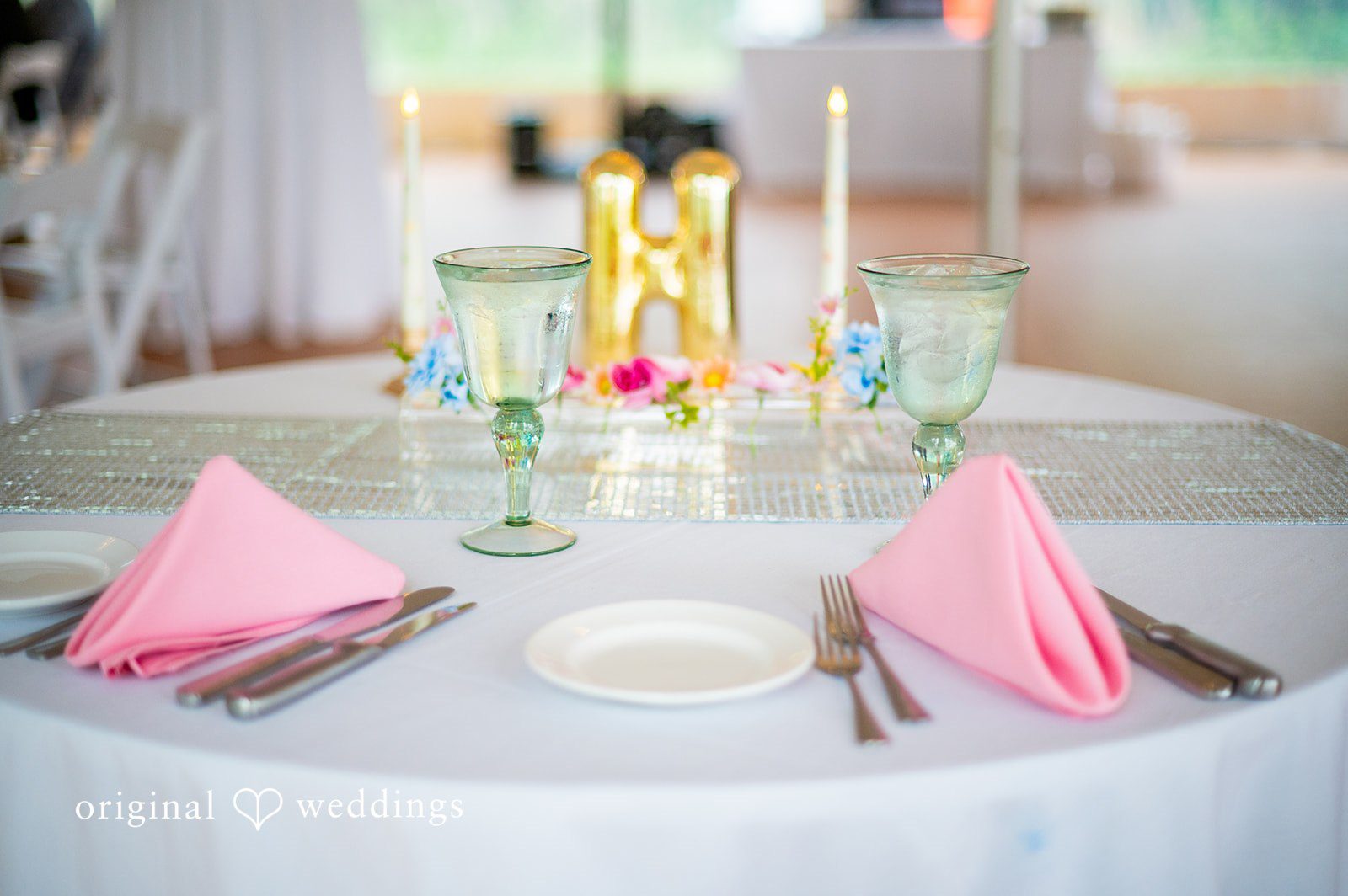Alex + Courtney A table setting decorated with light pink napkins.