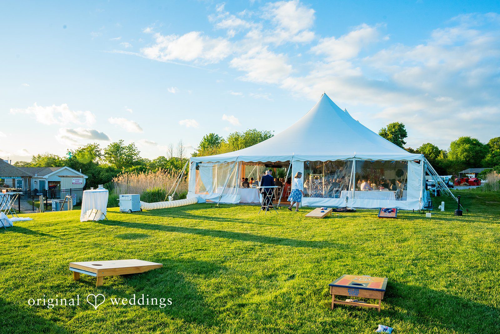 Alex + Courtney A white event tent pitched on a green grassy lawn.