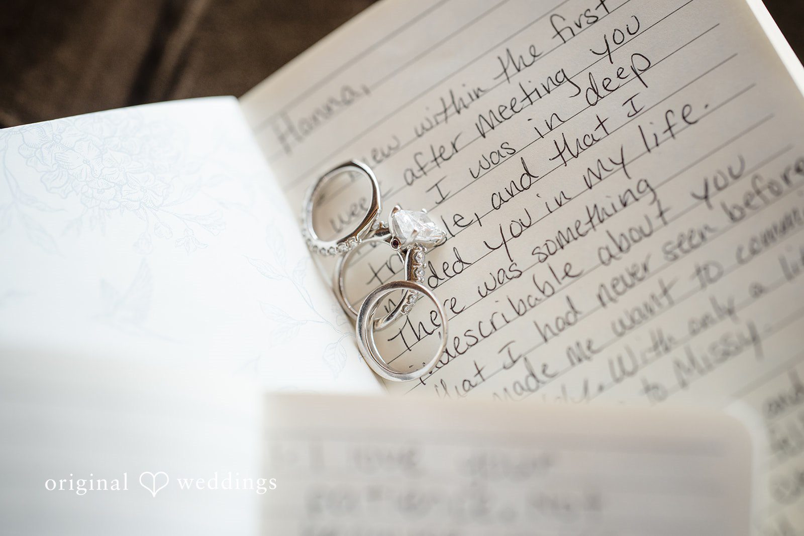 Hanna + Austin Close-up of a textured white wedding invitation with elegant text.