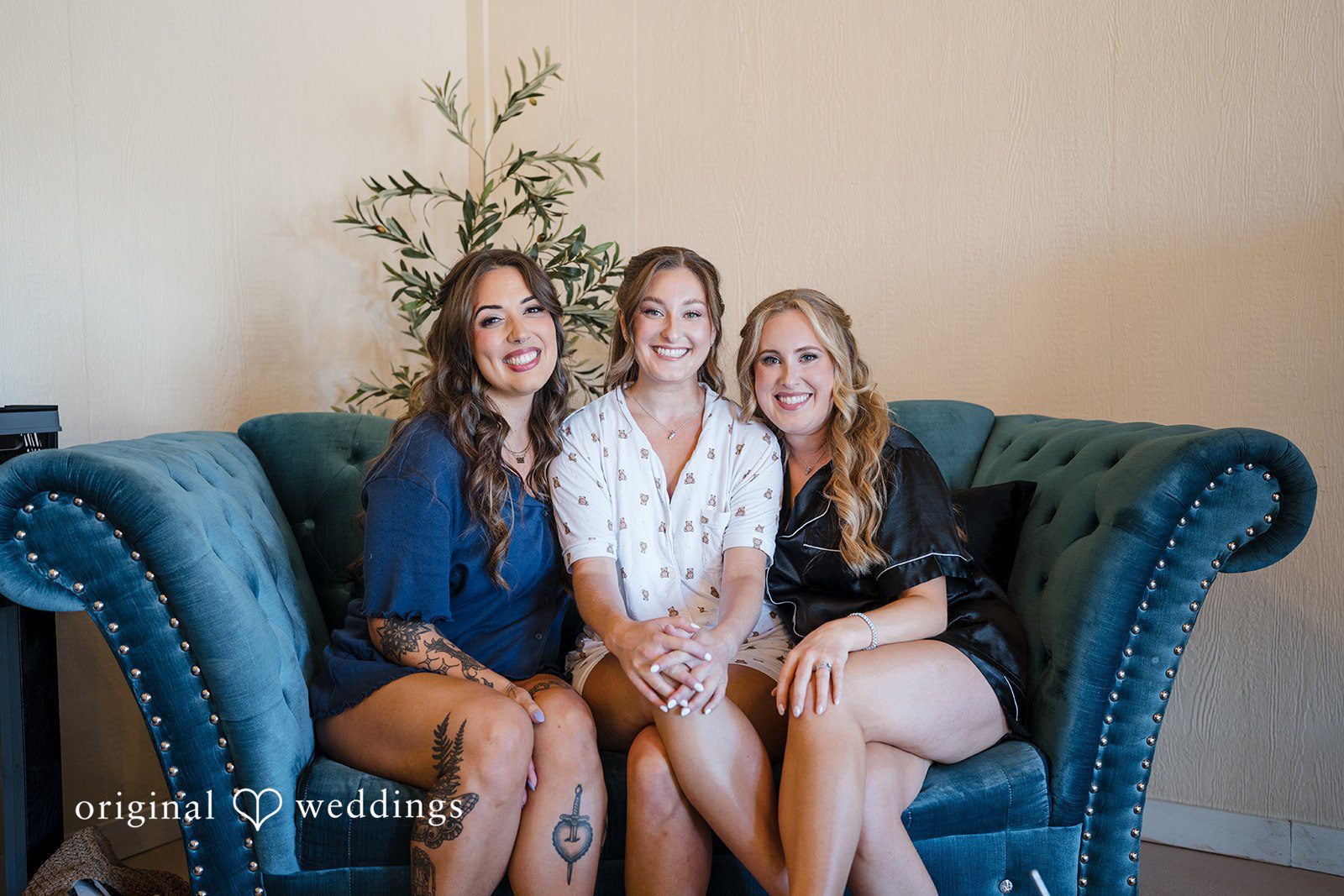 Hanna + Austin Three women sitting together and smiling on a blue couch.