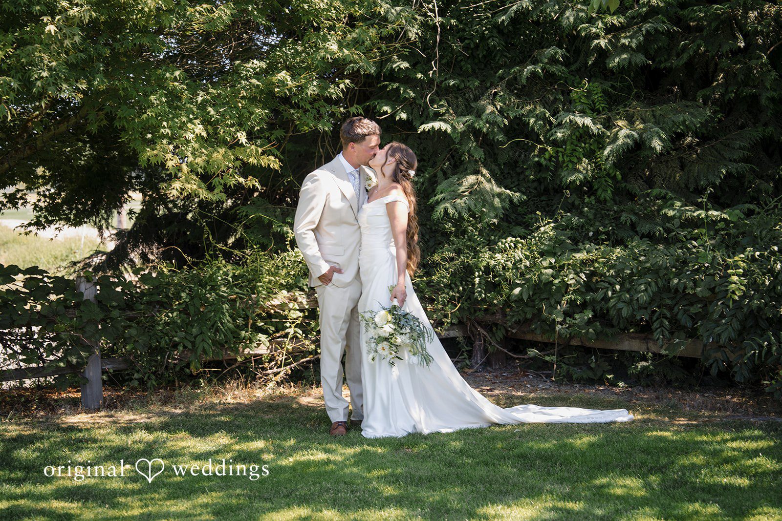 Hanna + Austin A bride and groom standing near trees.
