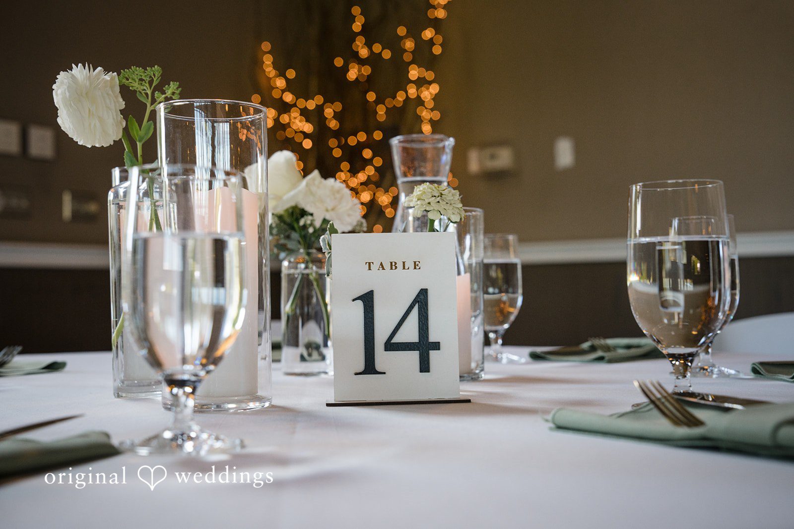 Hanna + Austin A glass champagne flute next to a table number fourteen card.