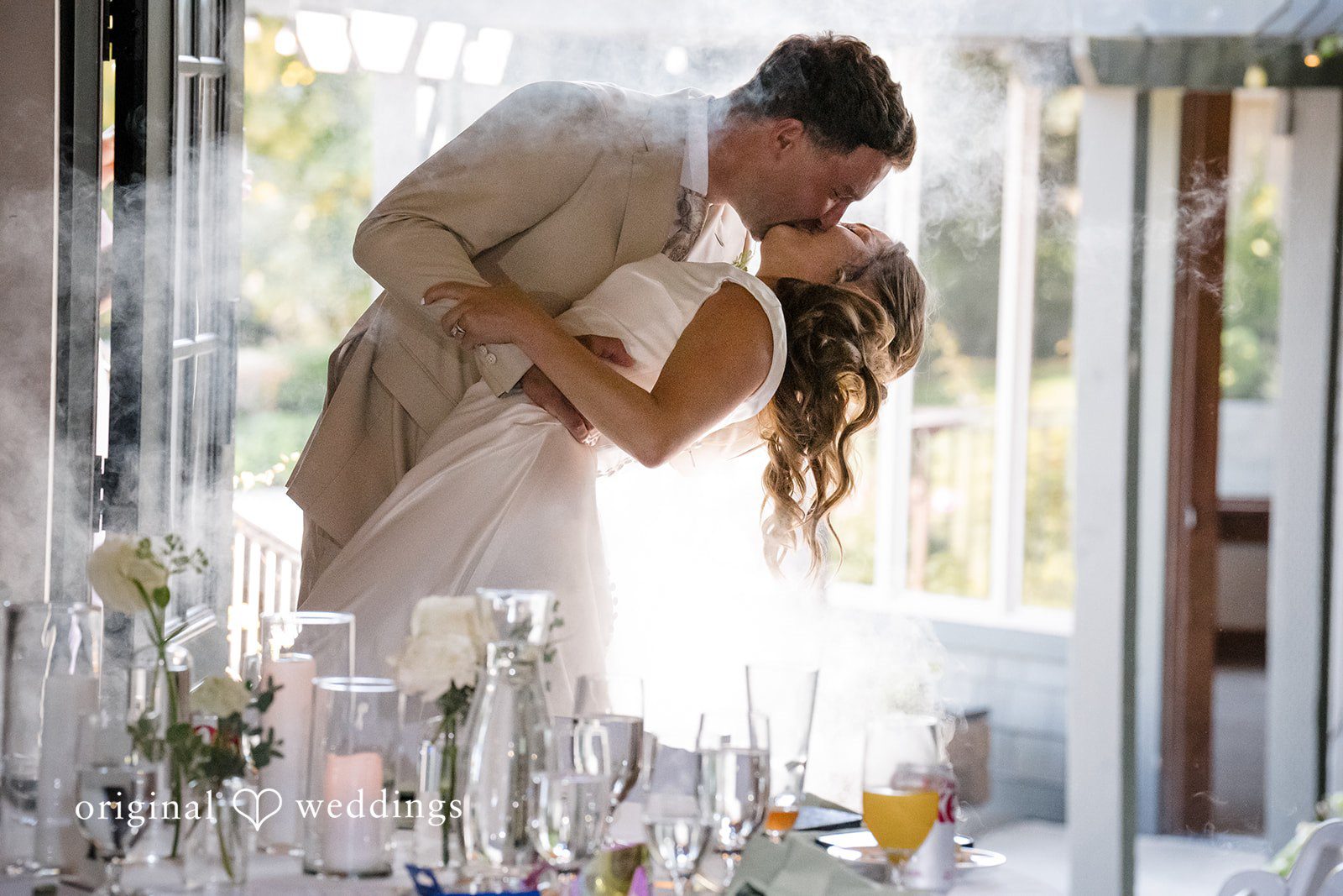 Hanna + Austin A bride and groom leaning in for a kiss behind glass.