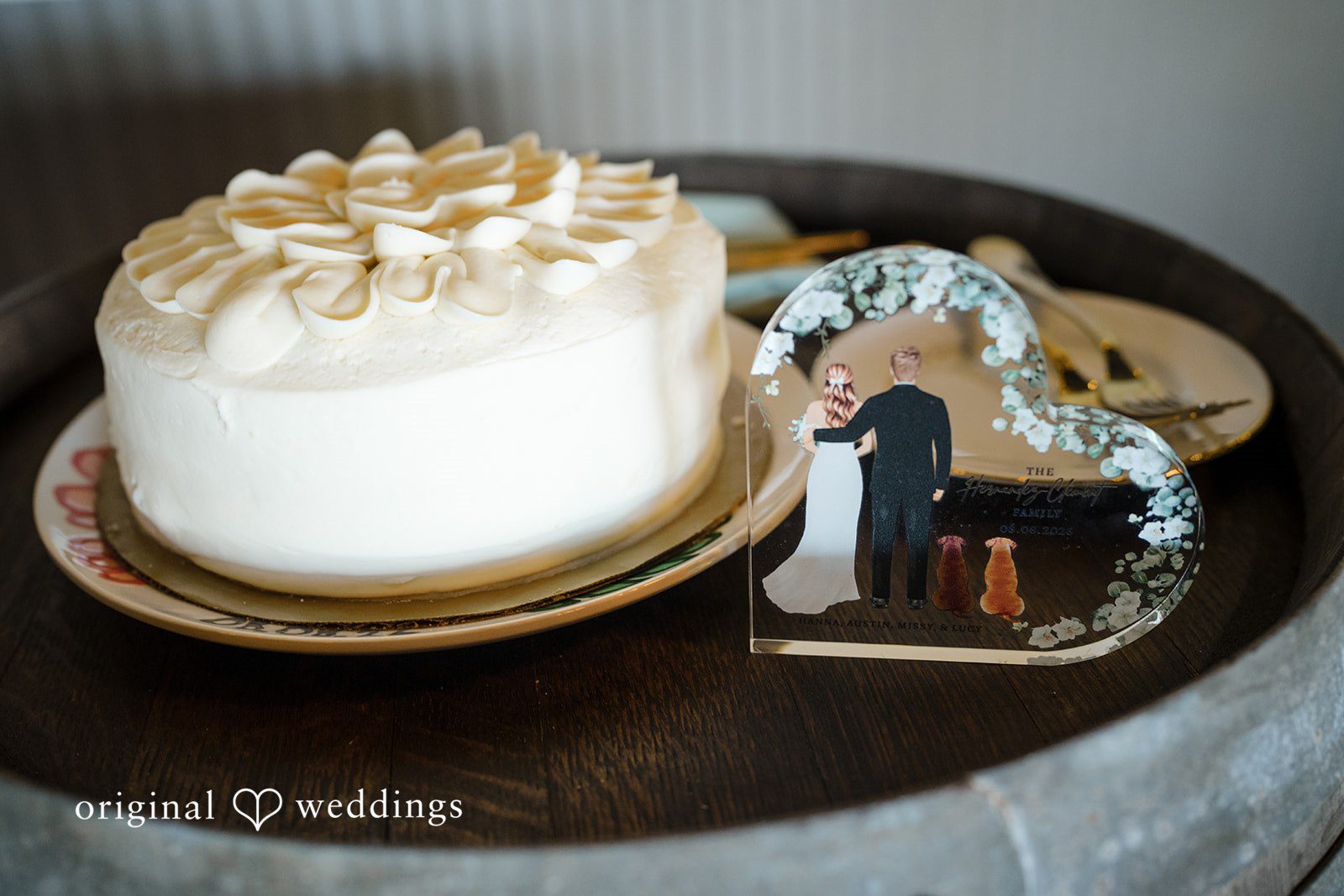 Hanna + Austin A small white frosted wedding cake on a dark stand.