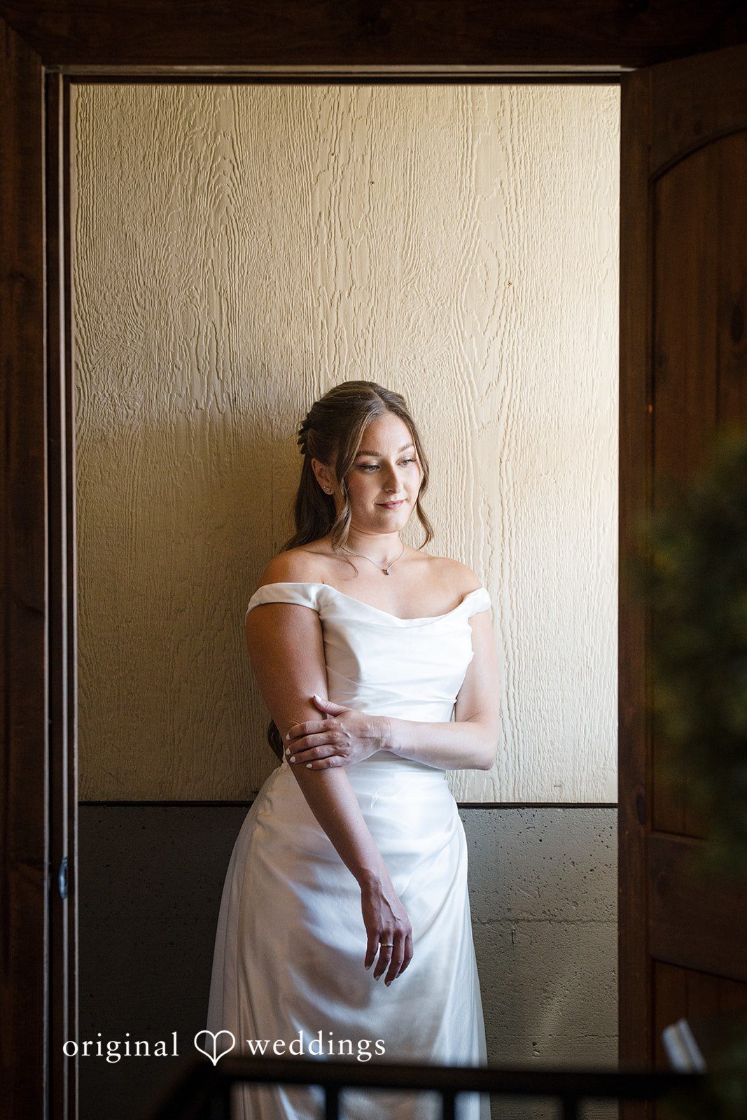 Hanna + Austin A bride in her wedding dress looking into a mirror.