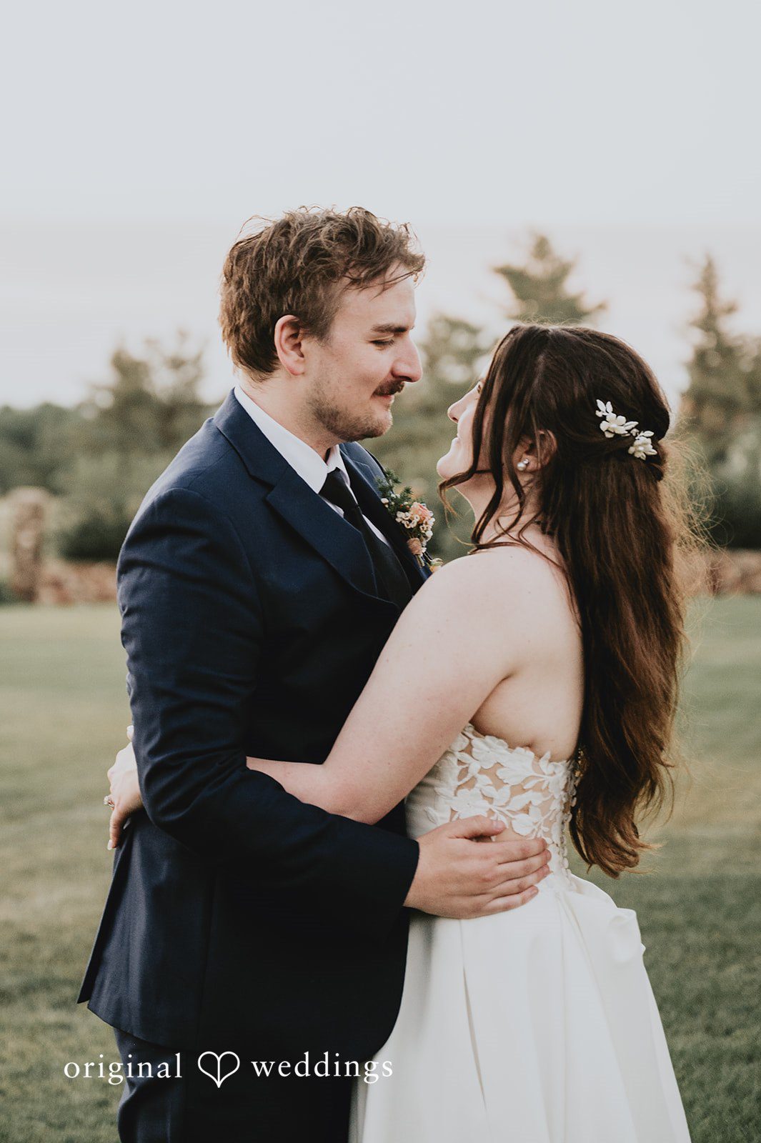 Bride and groom sharing a close embrace and smiling at Highlands Ranch Mansion.