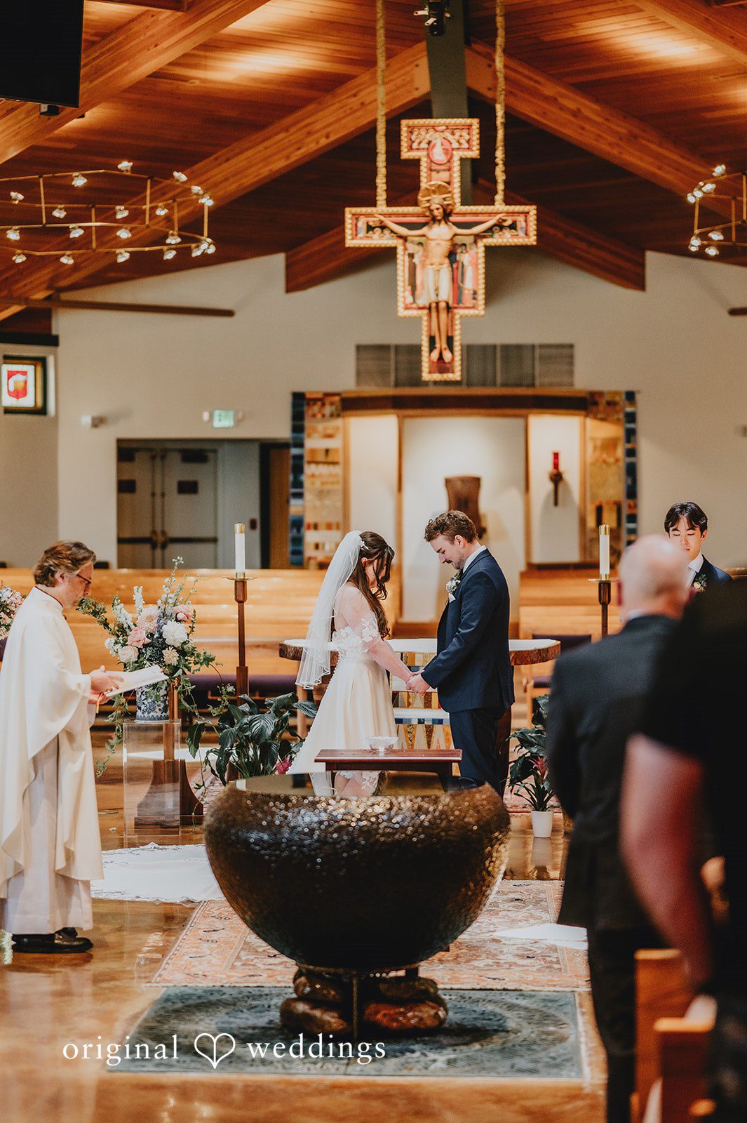 Bride and groom holding hands during their wedding ceremony.