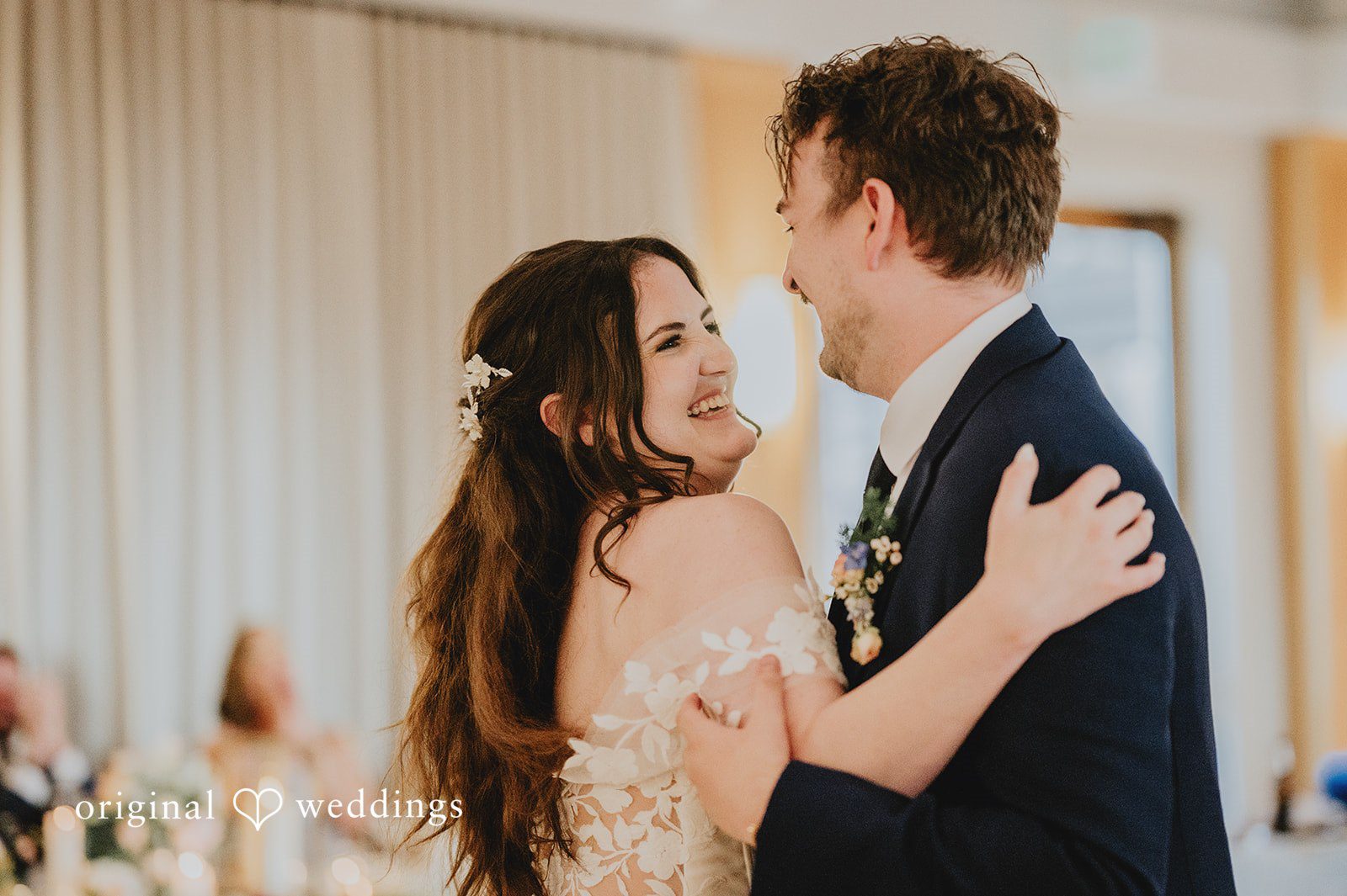 Close-up of the bride and groom smiling warmly at each other during a dance.