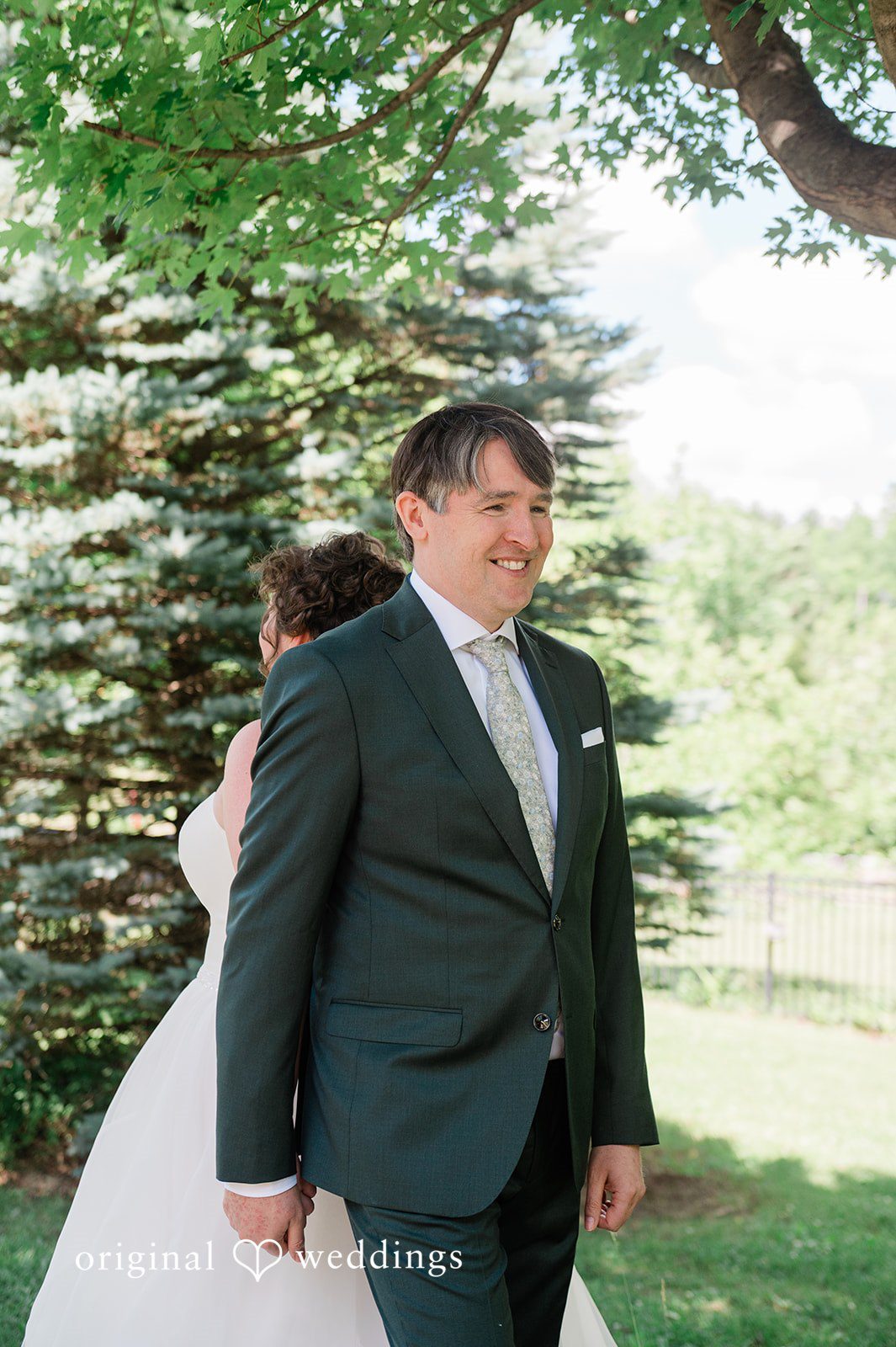 Carly + Seamus Groom in a dark suit standing at the front of a ceremony venue.