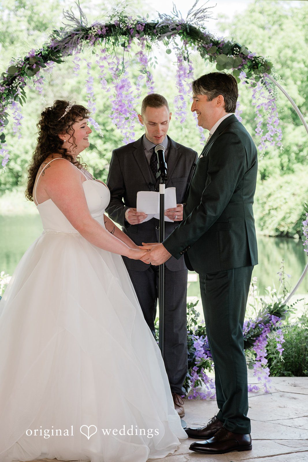 Carly + Seamus Bride and groom holding hands at the altar during their ceremony.