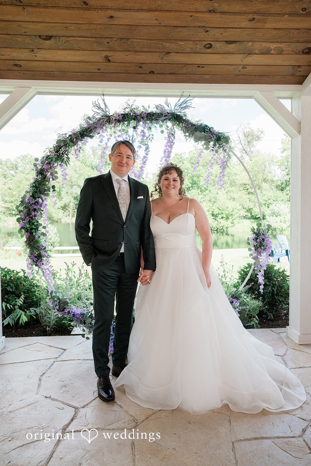 Carly + Seamus Bride and groom standing together and smiling at the front of a pavilion.