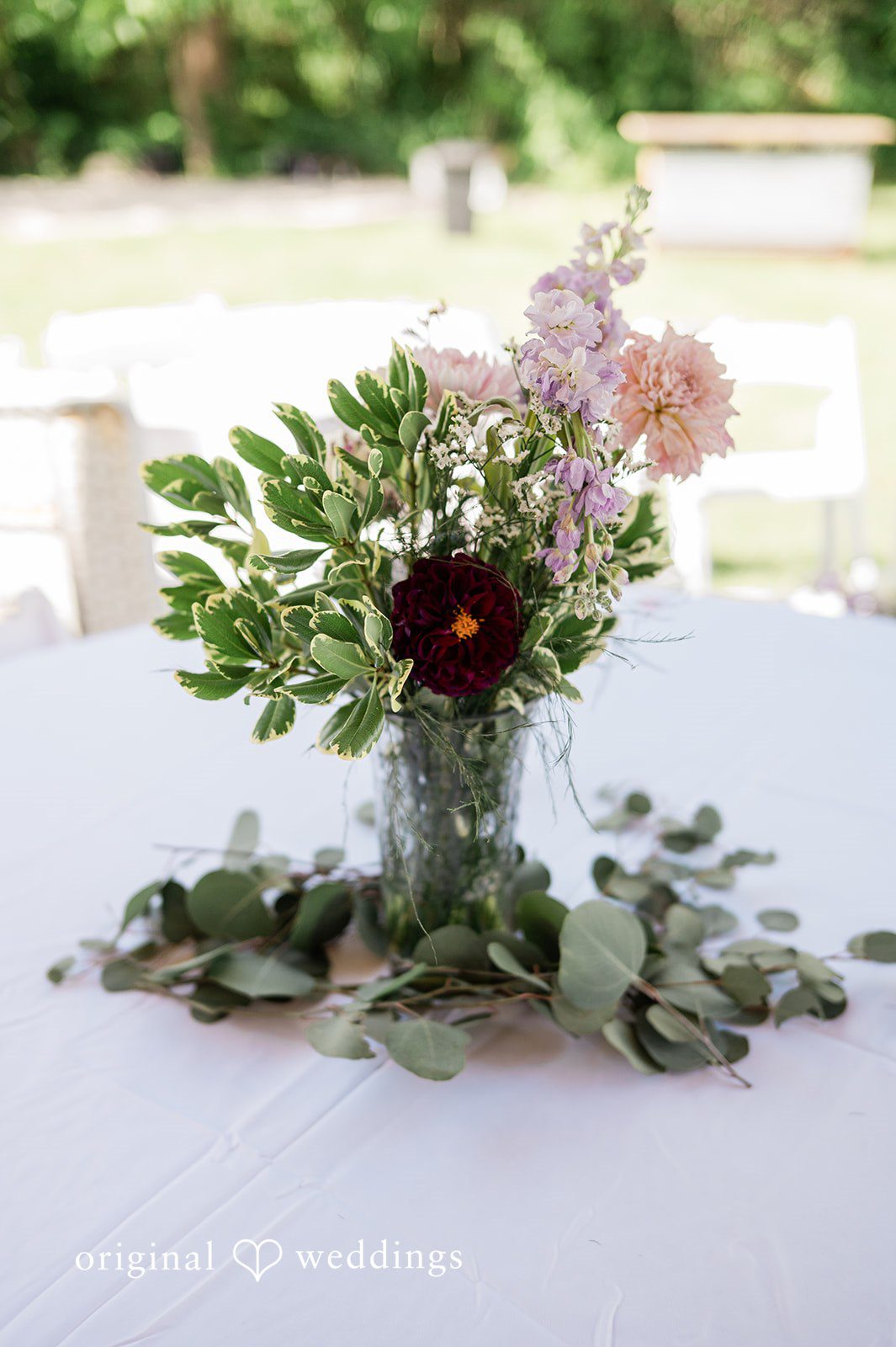 Carly + Seamus Floral centerpiece with pink and white flowers on a white tablecloth.