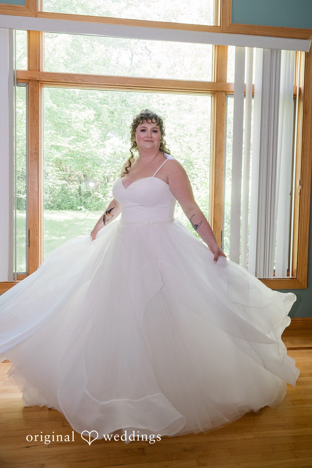 Carly + Seamus Bride in a full ballgown wedding dress smiling and posing in a bright room.