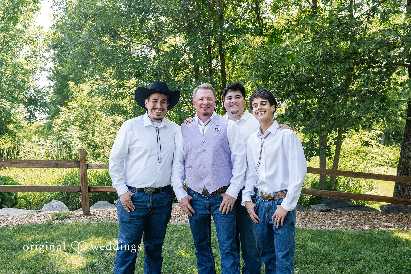Three men dressed in matching light blue shirts and trousers standing together.