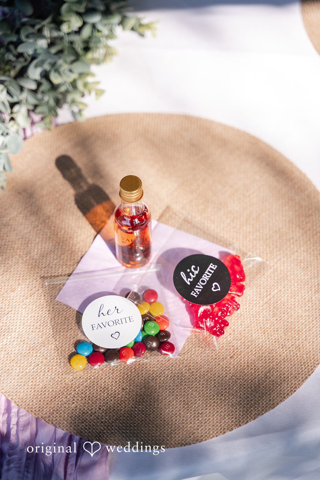 Flat lay of wedding invitations, confetti, and decorative items on a tan surface.