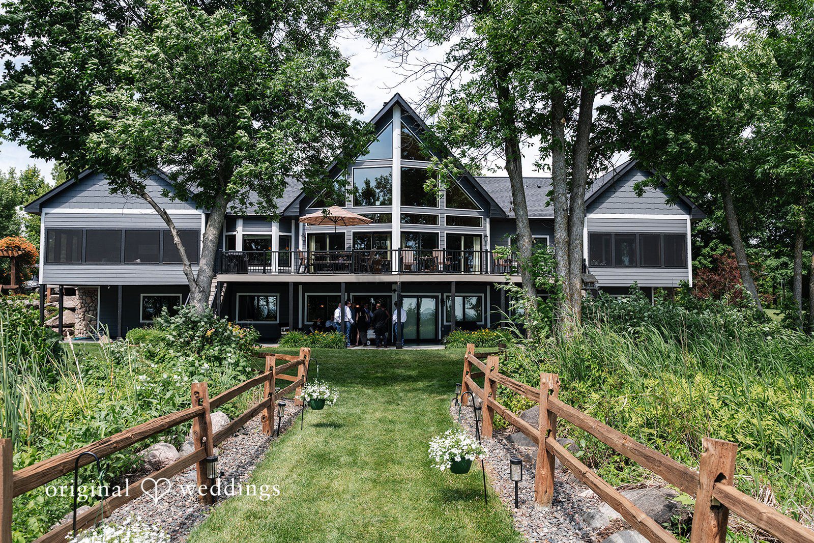 A multi-story wooden lodge with a boardwalk pathway leading up to it.