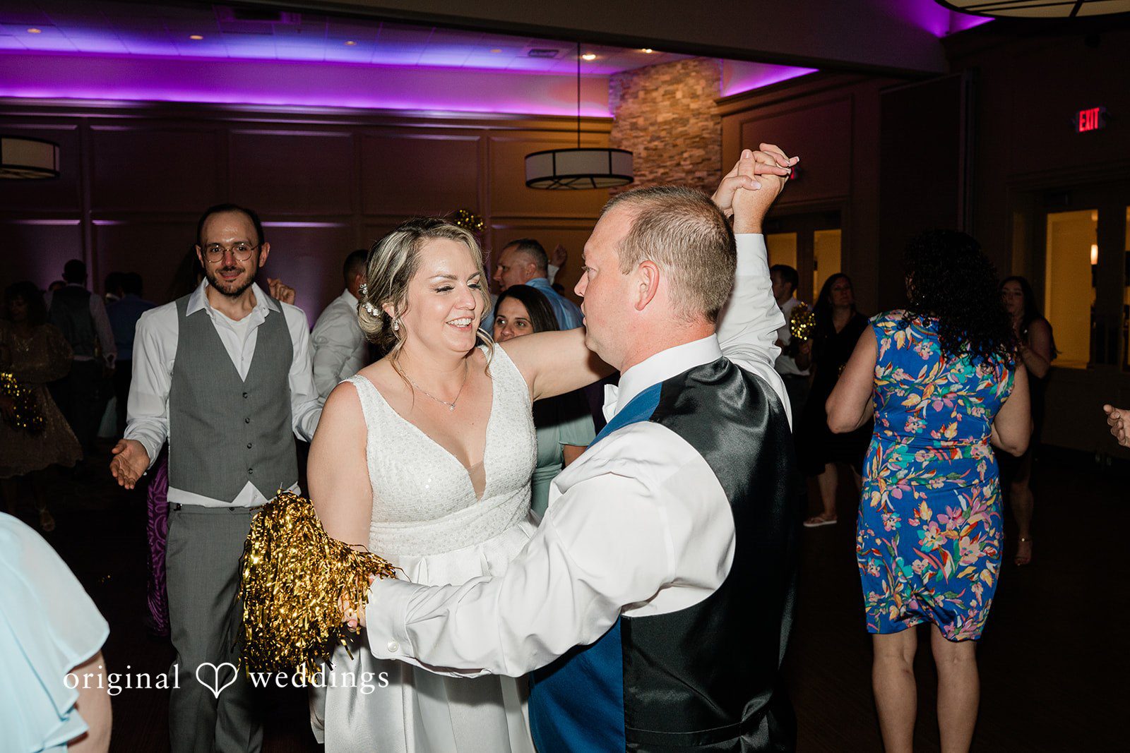 Jessica + Patrick A bride and groom dance joyfully while reception guests cheer them on.