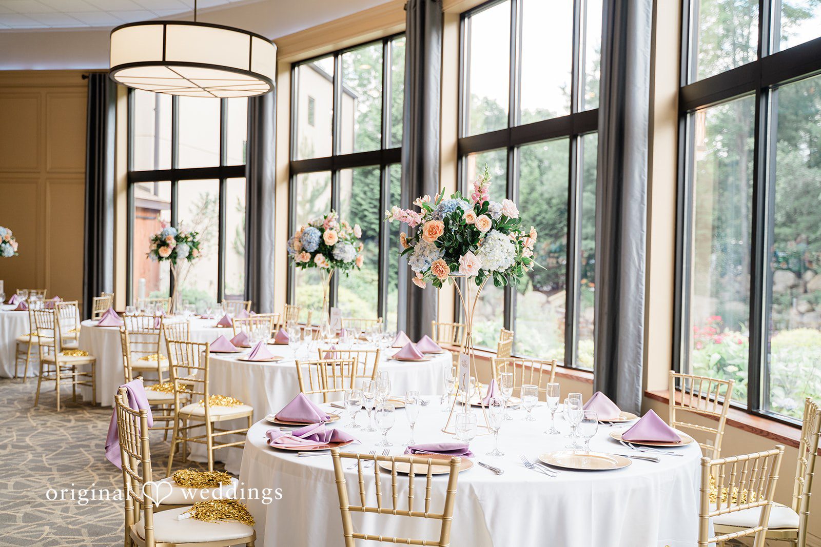 Jessica + Patrick A decorated round reception table with floral centerpieces and elegant place settings.