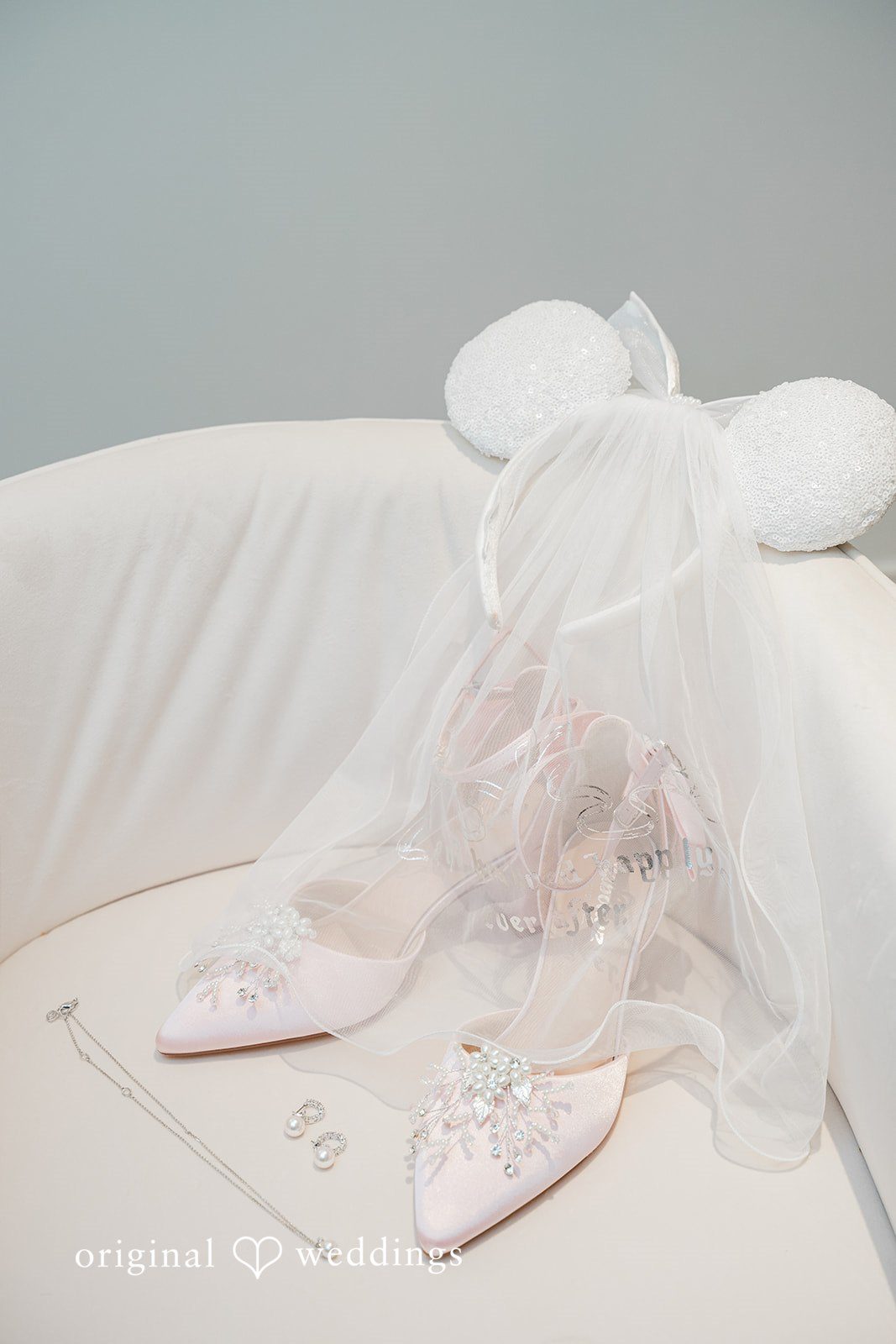 Jessica + Patrick Bridal details showing embellished wedding shoes and a veil resting on a white surface.