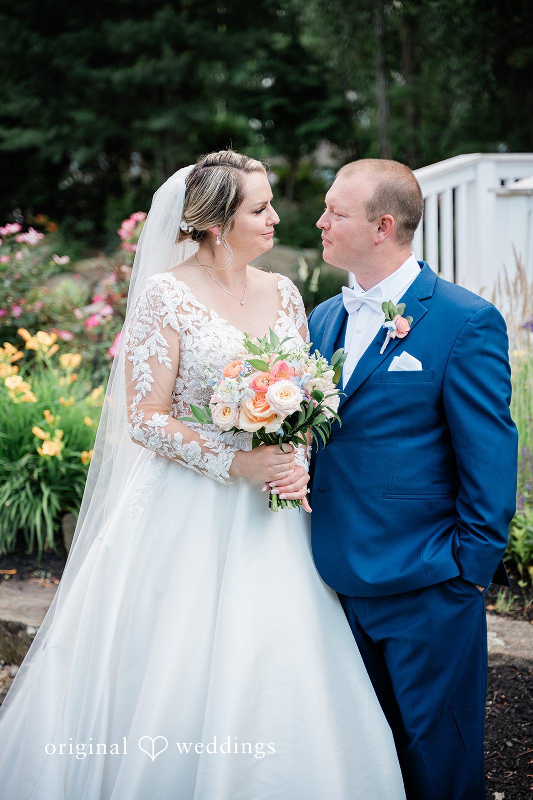 Jessica + Patrick A bride and groom stand close together looking at each other affectionately.